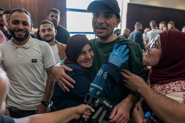 Palestinians celebrate as released Palestinian prisoners arrive after an exchange...