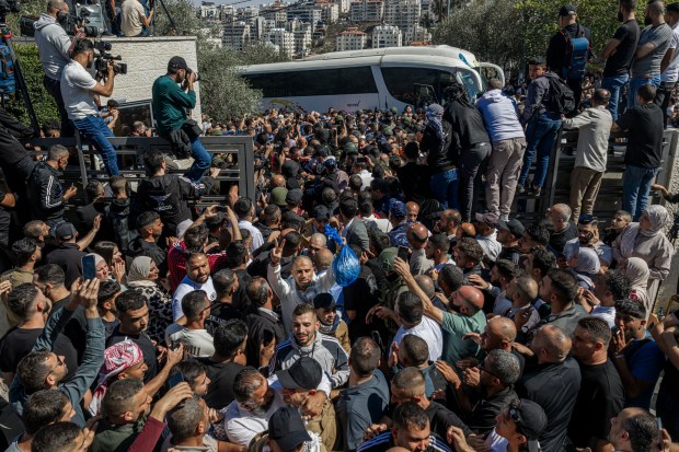 Palestinians celebrate as buses of released Palestinian prisoners arrive after...