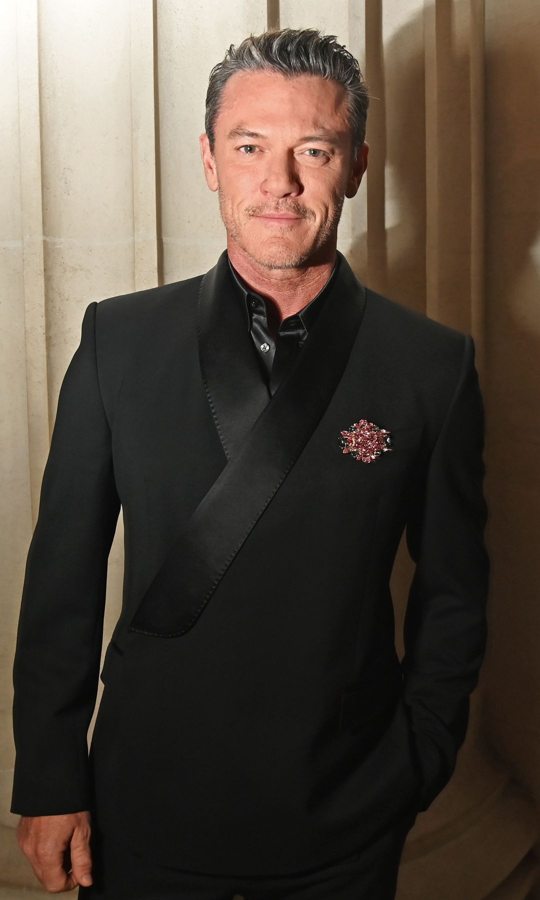 Luke Evans wearing a black suit