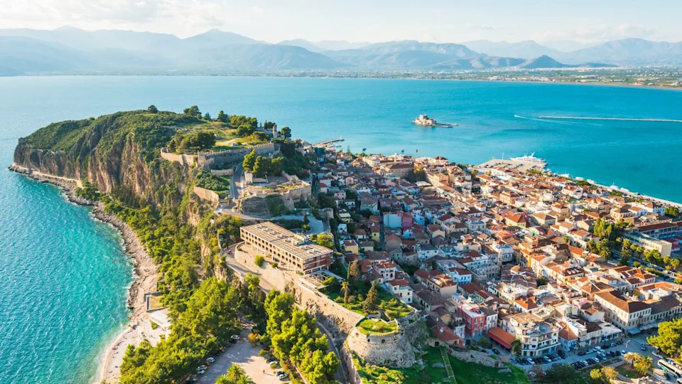 Beautiful Nafplion city in Greece view from above with green peninsula surrounded by Mediterranean sea with selective focus