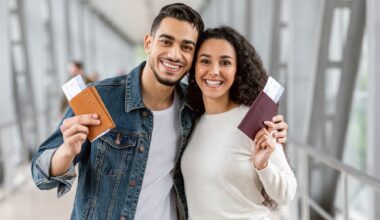 A Couple holding passports at an airport with boarding passes inside.