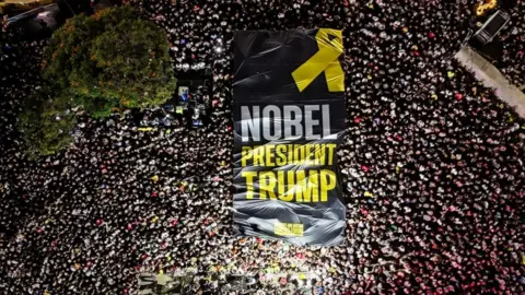 Reuters banner at tel aviv rally calling for a nobel for trump