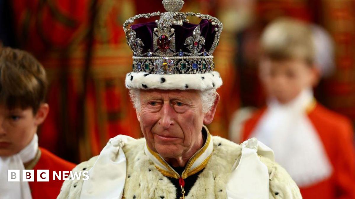 King Charles wears a bejewelled crown and a large fur robe.