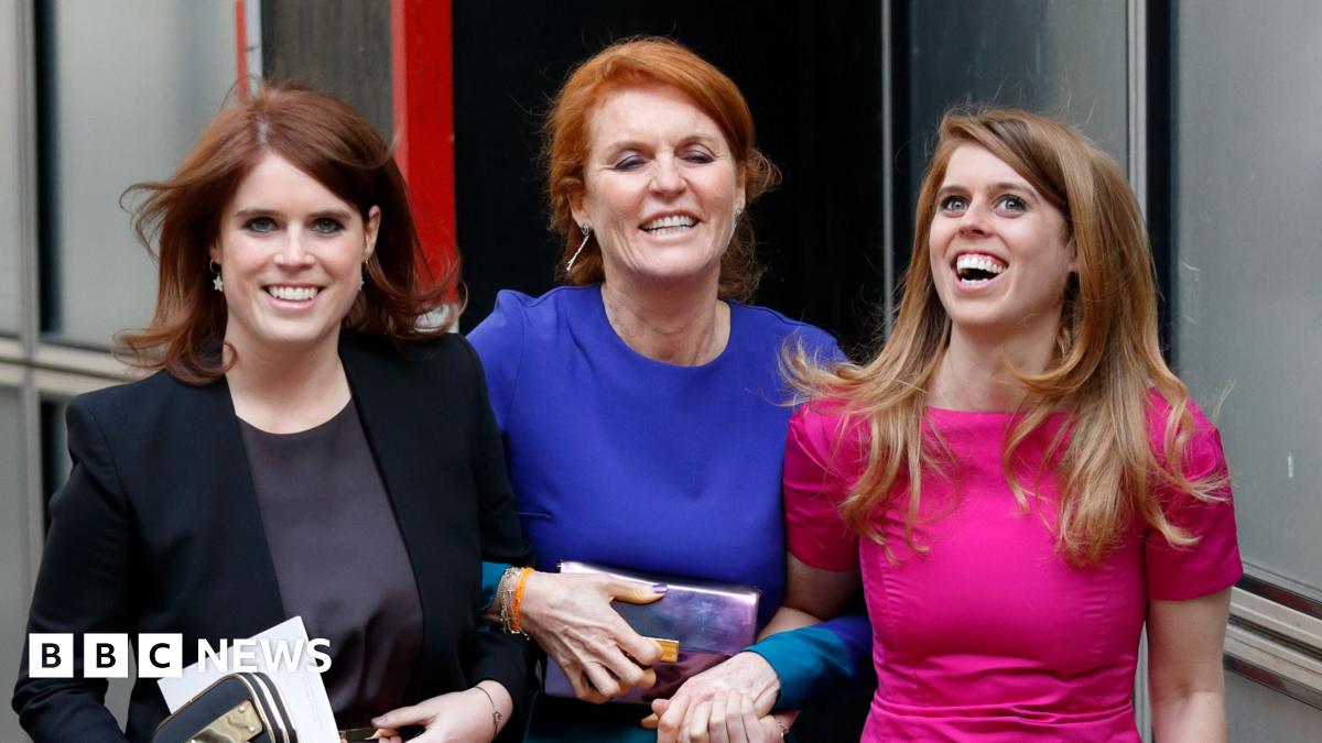 Princess Beatrice, Sarah Ferguson and Princess Eugenie in dresses smile as they link arms walking