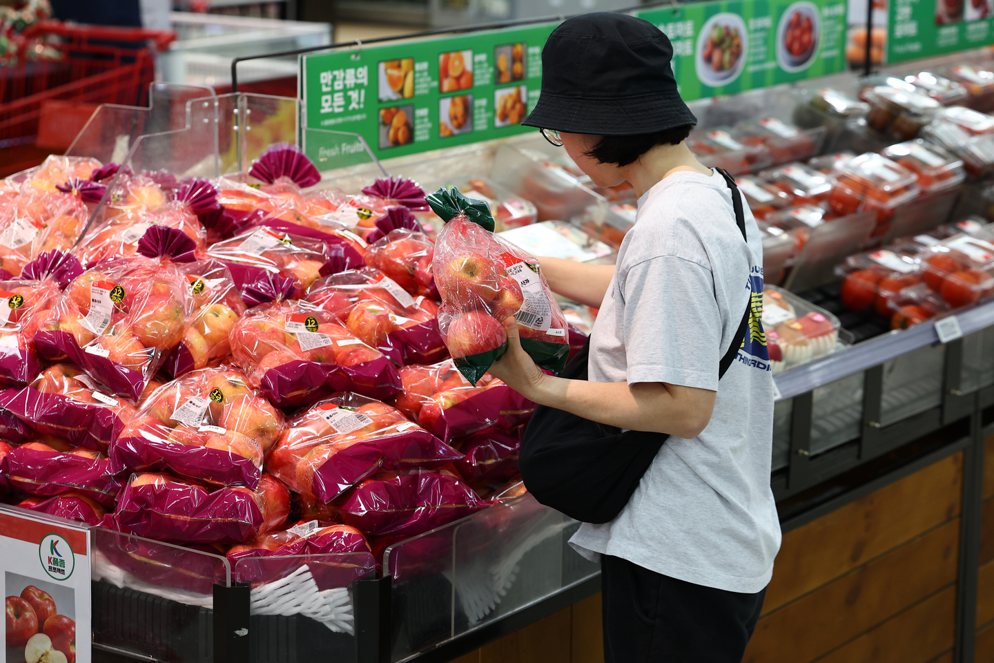 A shopper picks out apples at a supermarket in Korea on Oct. 8. [YONHAP]