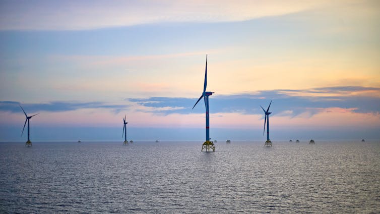wind turbines at sea, sunset sky