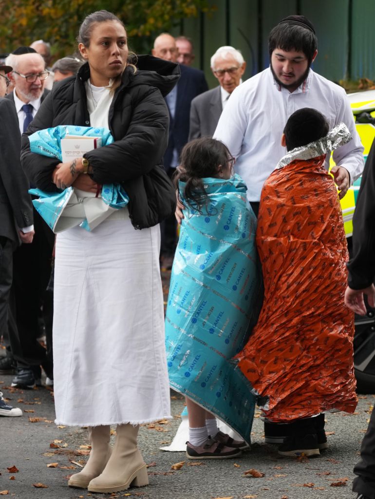 MANCHESTER, ENGLAND - OCTOBER 2: Members of the public and congregants seen as Police and other emergency responders attend the Heaton Park Hebrew Congregation Synagogue, where multiple were injured after stabbing and car attack on Yom Kippur, on October 2, 2025 in the Crumpsall suburb of Manchester, England. Greater Manchester Police said they were called to the scene shortly after 9:30 AM, when a witness said the assailant drove a car at people and then stabbed someone. Police then shot the suspected attacker. (Photo by Christopher Furlong/Getty Images)