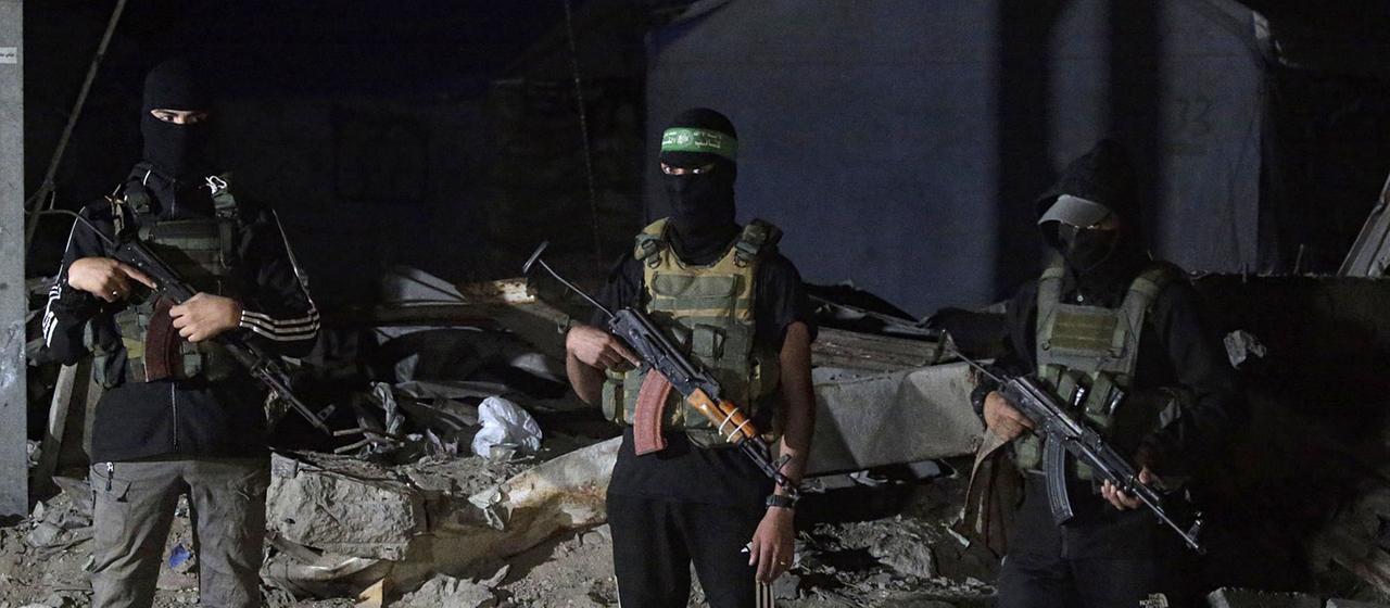 Palästinensische Kämpfer der Izz ad-Din al-Qassam-Brigaden der Hamas bewachen Fahrzeuge des Internationalen Komitees vom Roten Kreuz in Gaza-Stadt.