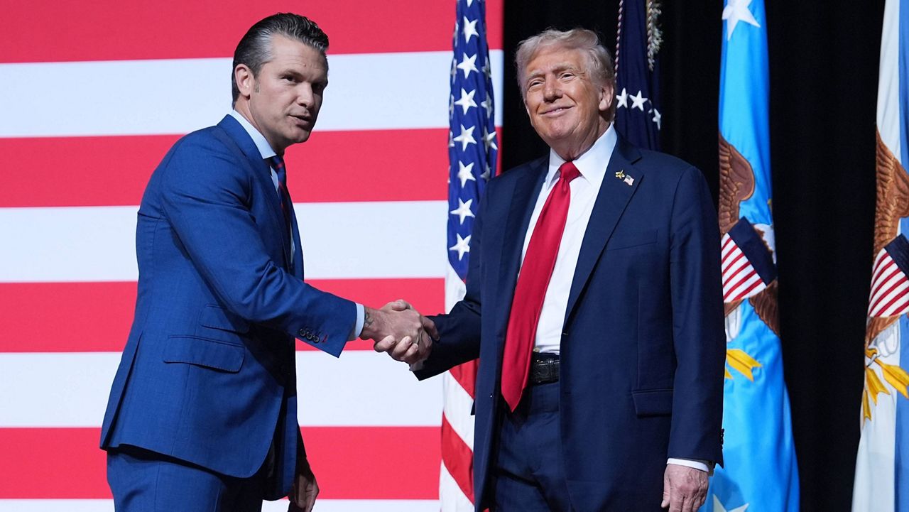 President Donald Trump is greeted by Secretary of Defense Pete Hegseth before speaking to a gathering of top U.S. military commanders at Marine Corps Base Quantico, Tuesday, Sept. 30, 2025, in Quantico, Va. (AP Photo/Evan Vucci)