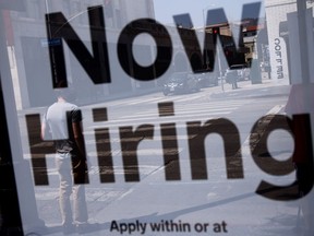 A now hiring sign hangs on the door of a business. (Files)