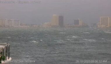 Rough waters and gray skies over Kingston harbour, with city buildings in the background ahead of Hurricane Melissa's landfall.