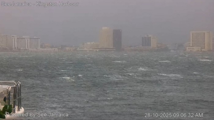 Rough waters and gray skies over Kingston harbour, with city buildings in the background ahead of Hurricane Melissa's landfall.