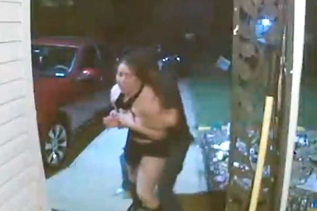 Video still of a woman screaming as she is pulled away by an unseen individual.