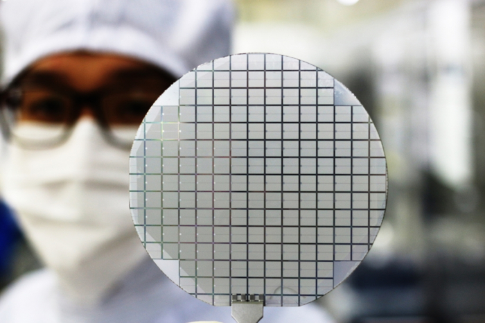 A Samsung Electronics employee holds a semiconductor wafer