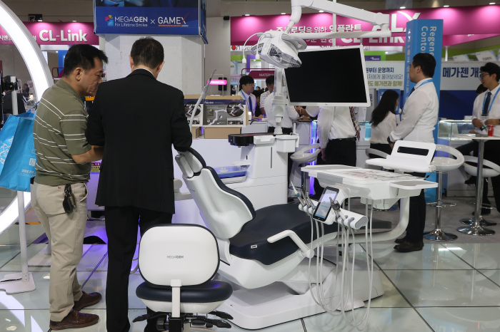 Visitors examine dental equipment at a dental equipment exhibition in Korea in 2025 (Courtesy of Yonhap)