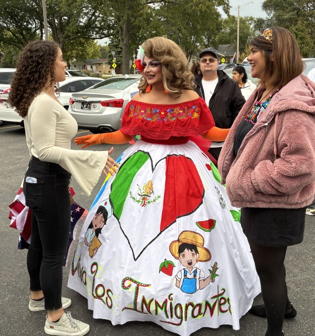 Lola Madison, center, made a dress supporting immigrants to wear at the march and rally Monday in Waukegan. (Steve Sadin/For the Lake County News-Sun)