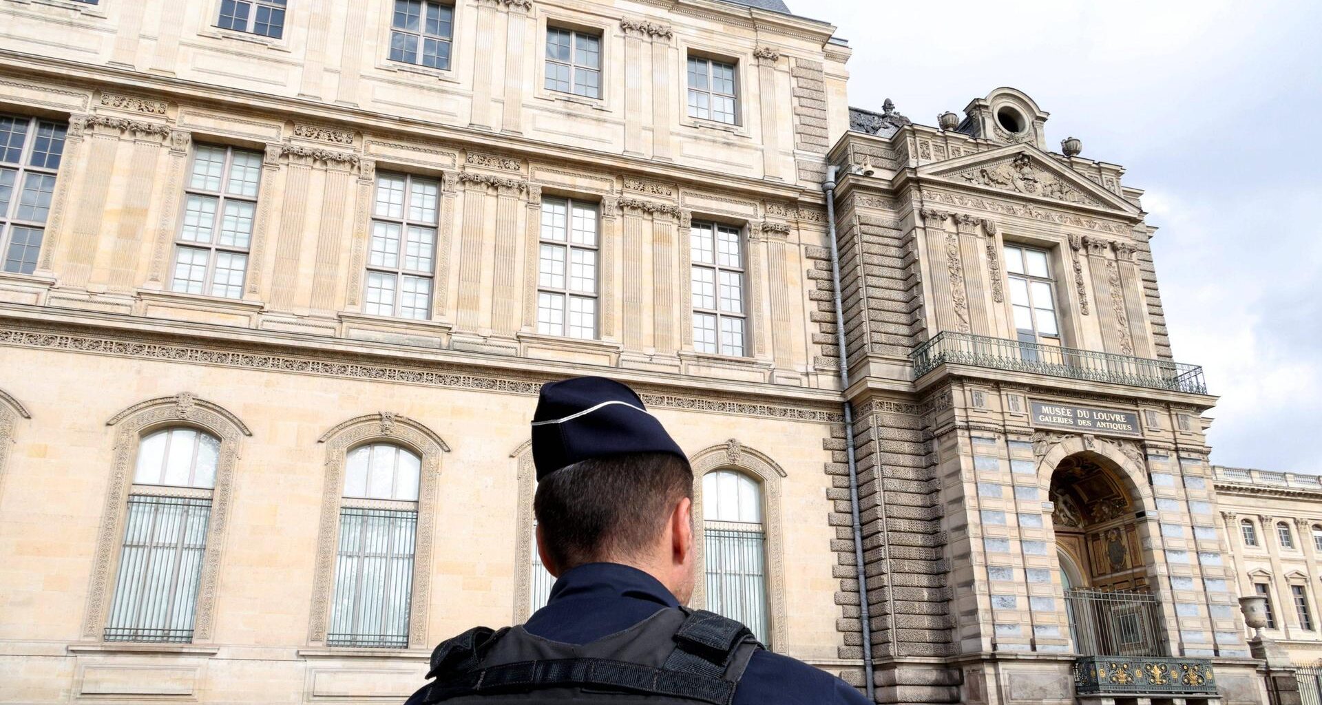 Vor dem Louvre steht ein Polizist.