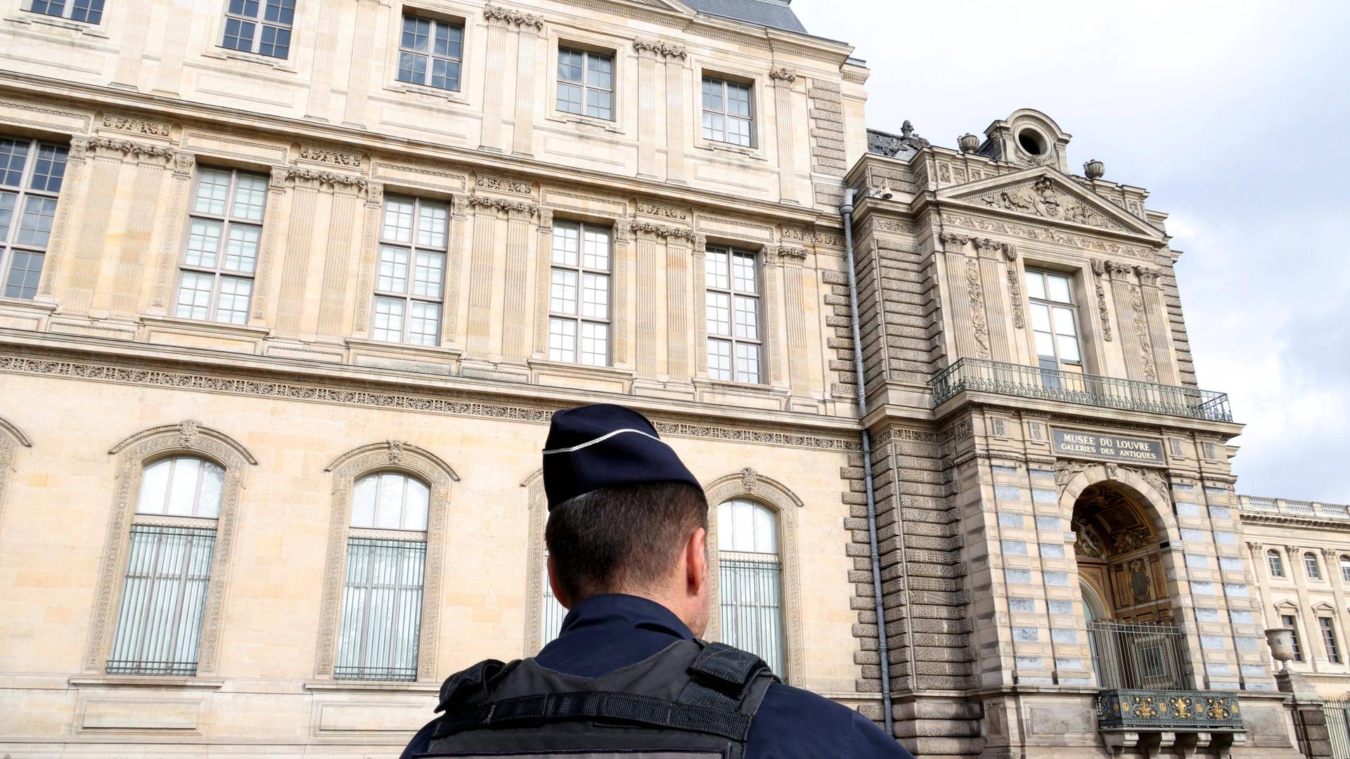 Vor dem Louvre steht ein Polizist. Vor dem Louvre steht ein Polizist.