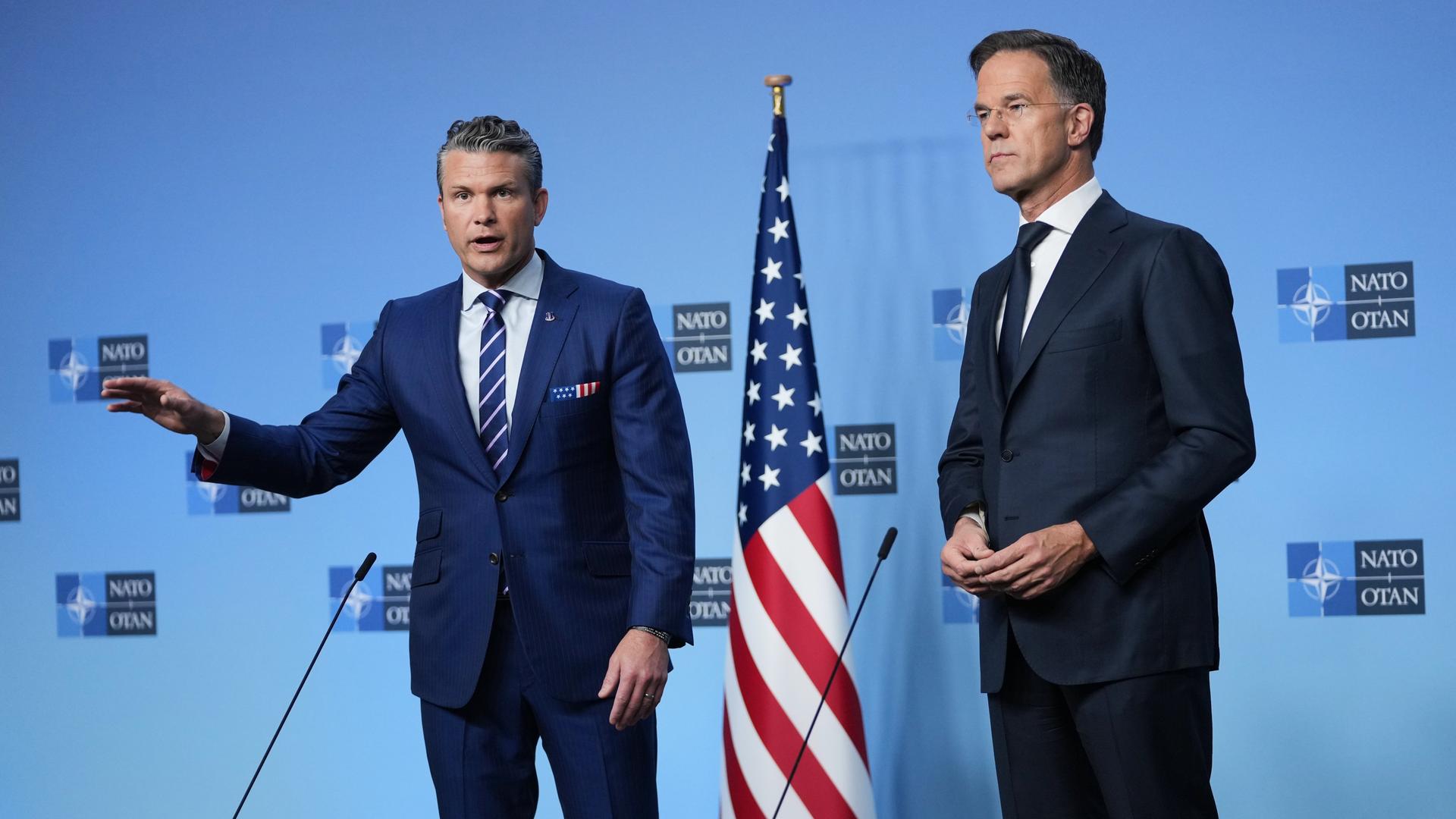 NATO-Generalsekretär Rutte und US-Verteidigungsminister Hegseth stehen beim Treffen der Verteidigungsminister in Brüssel nebeneinander auf der Bühne. NATO-Generalsekretär Rutte und US-Verteidigungsminister Hegseth stehen beim Treffen der Verteidigungsminister in Brüssel nebeneinander auf der Bühne.