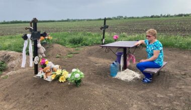 A woman sits at the grave of her 8-year-old grandson, Ivan. She also lost both of her children and her husband in the Russian strike
