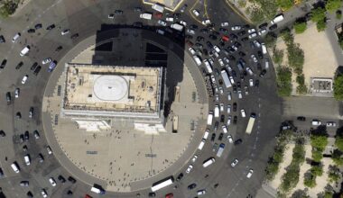 Senkrechter Blick aus der Luft: Autos fahren im Kreis um den Arc de Triomphe herum.