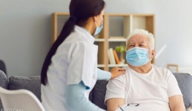 Eine weibliche Pflegekraft mit einem alten Mann