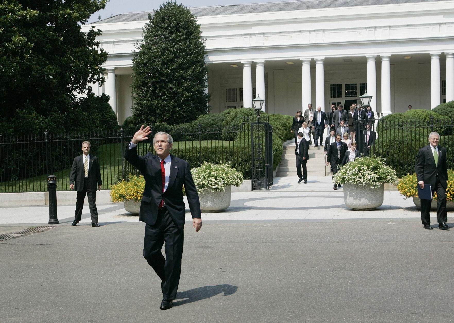 President Bush waves as walks away from the East Wing of the White House