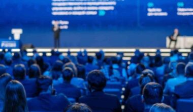 Audience attending a business and technology conference in a large auditorium. (Adobe Stock Photo)