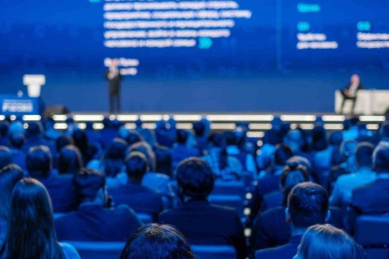 Audience attending a business and technology conference in a large auditorium. (Adobe Stock Photo)