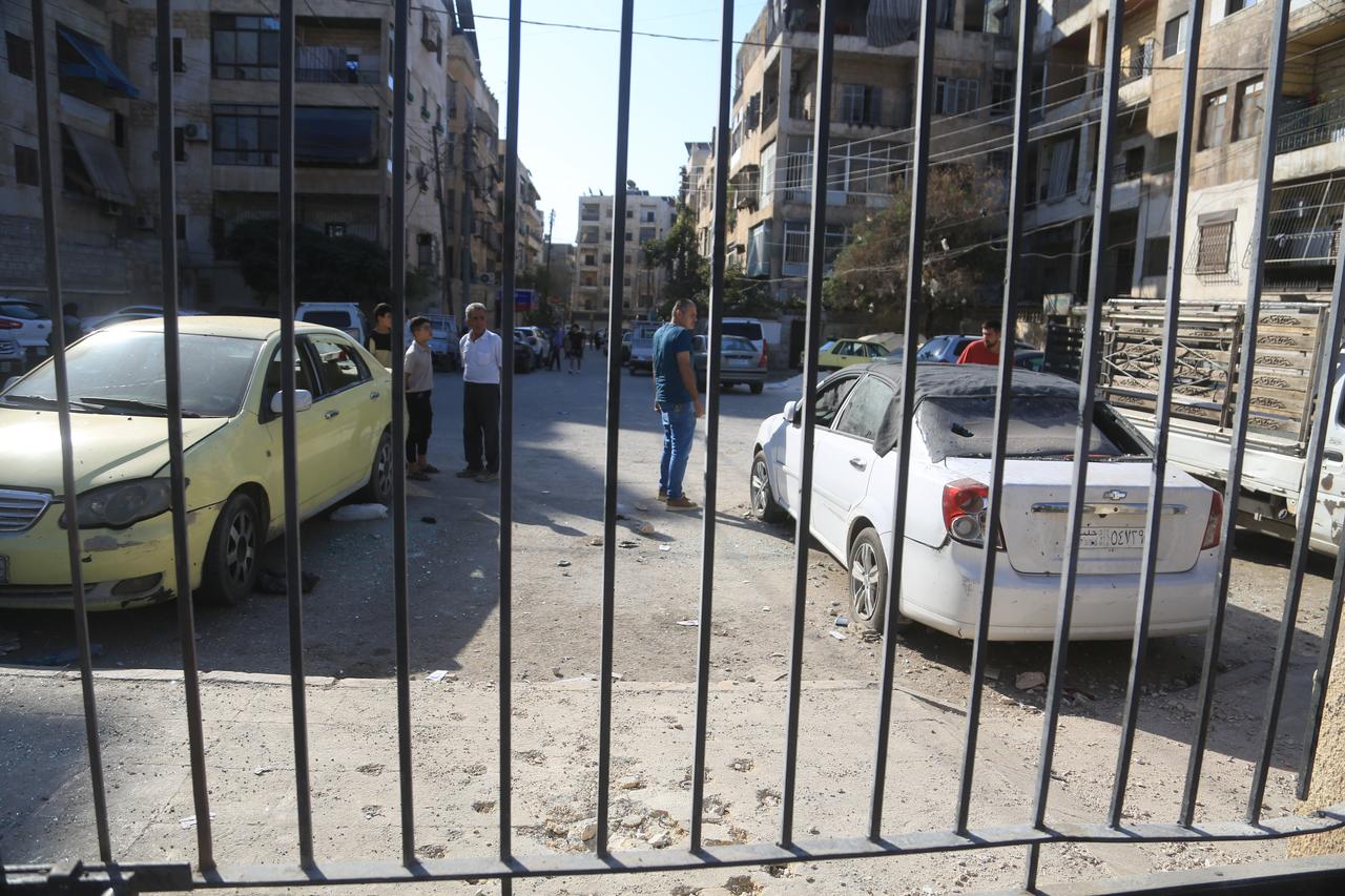 Syrians inspect cars damaged during the clashes between the terrorist organization PKK/YPG, which operating under the name SDF, and Syrian security forces after ceasefire agreement in Aleppo, Syria on October 07, 2025. (AA Photo)