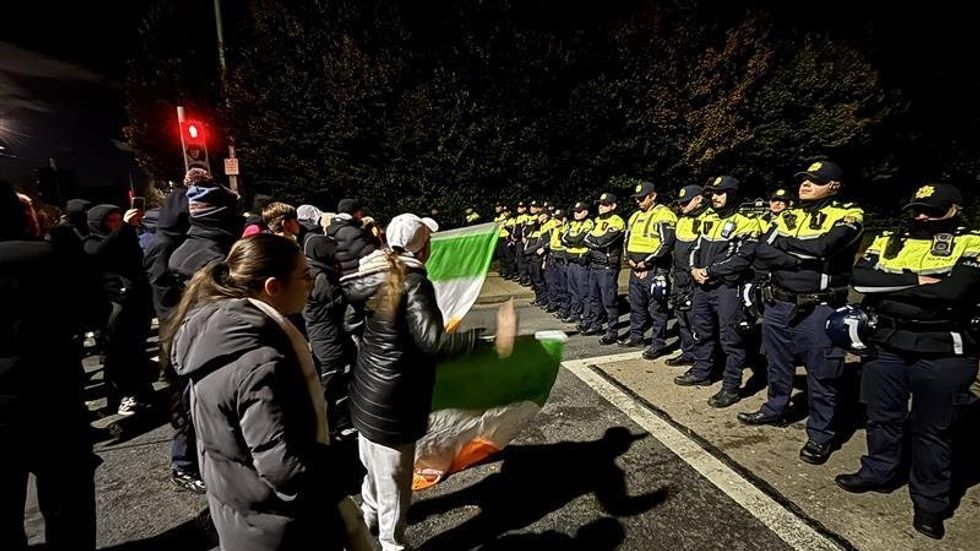\u200bGardai officers block protesters near the hotel