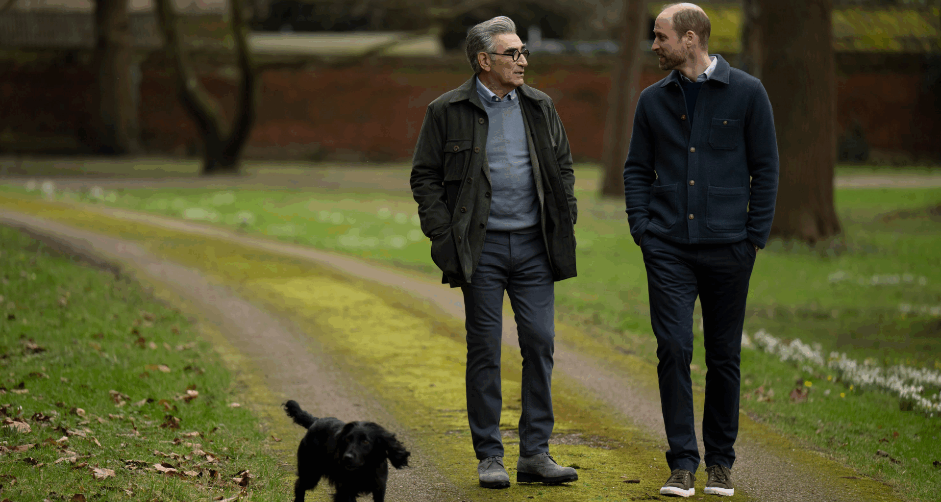 Prince William walking with Eugene Levy and Orla the dog through a park