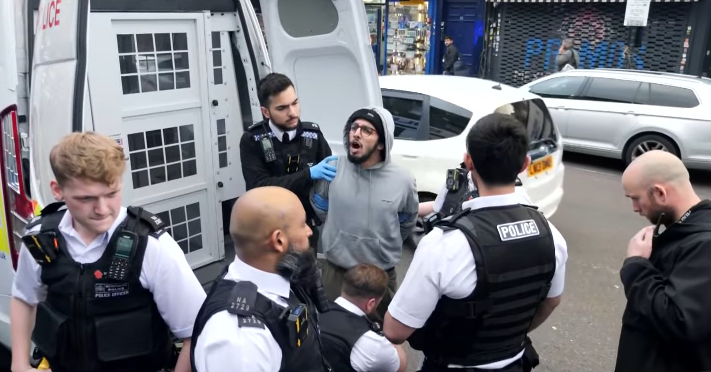 Brahim Kaddour-Cherif being arrested by police officers.