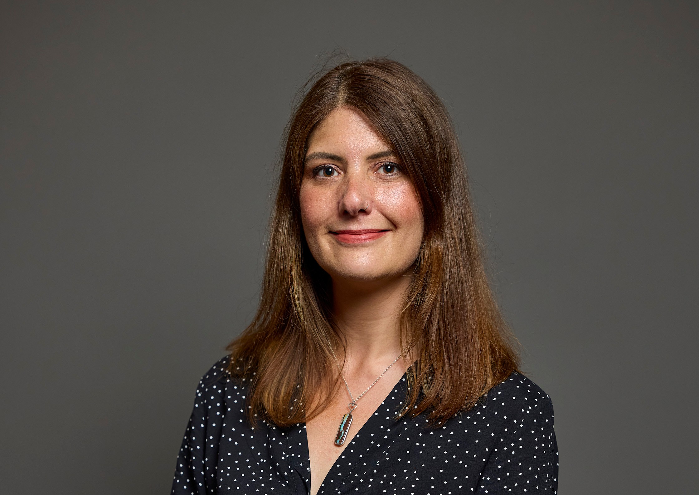Cat Eccles, the Labour MP for Stourbridge, smiles at the camera while wearing a black polka-dot dress and a heart-buckled belt.