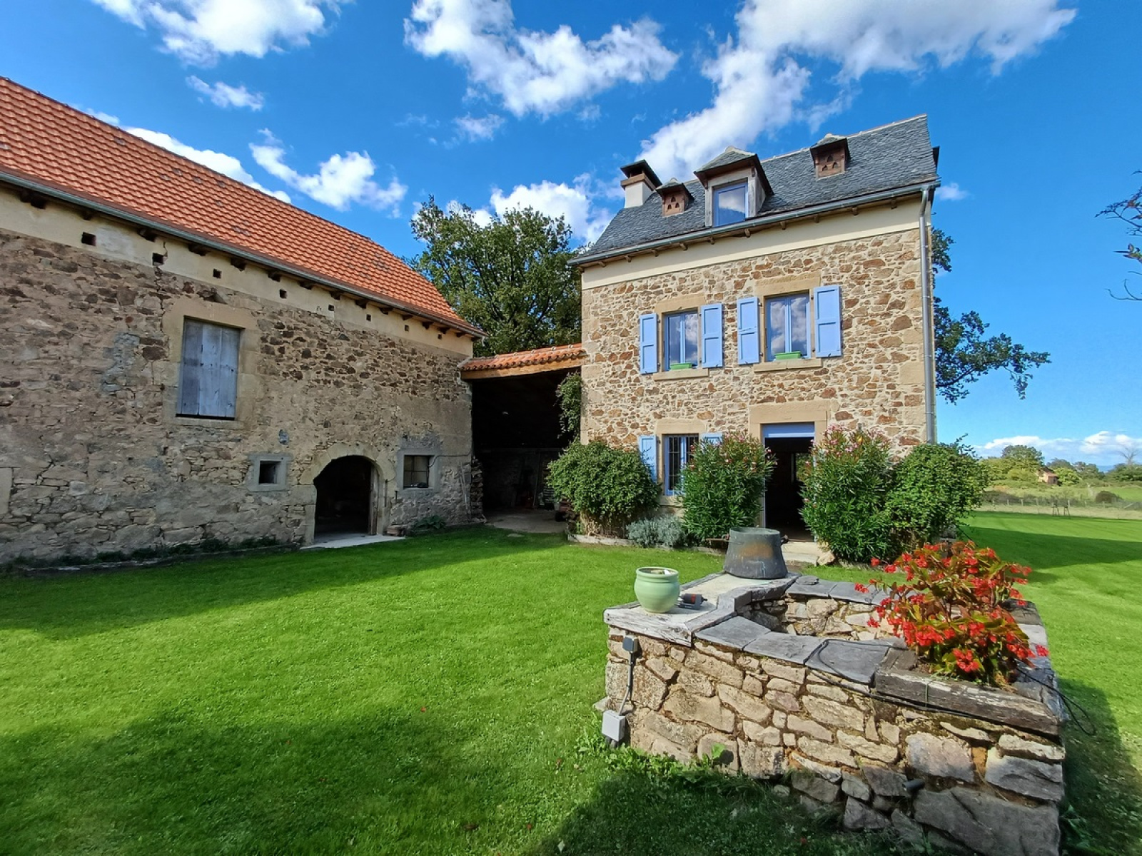 A renovated stone farmhouse in a rural setting, with a large attic bedroom and a 70 m² barn.