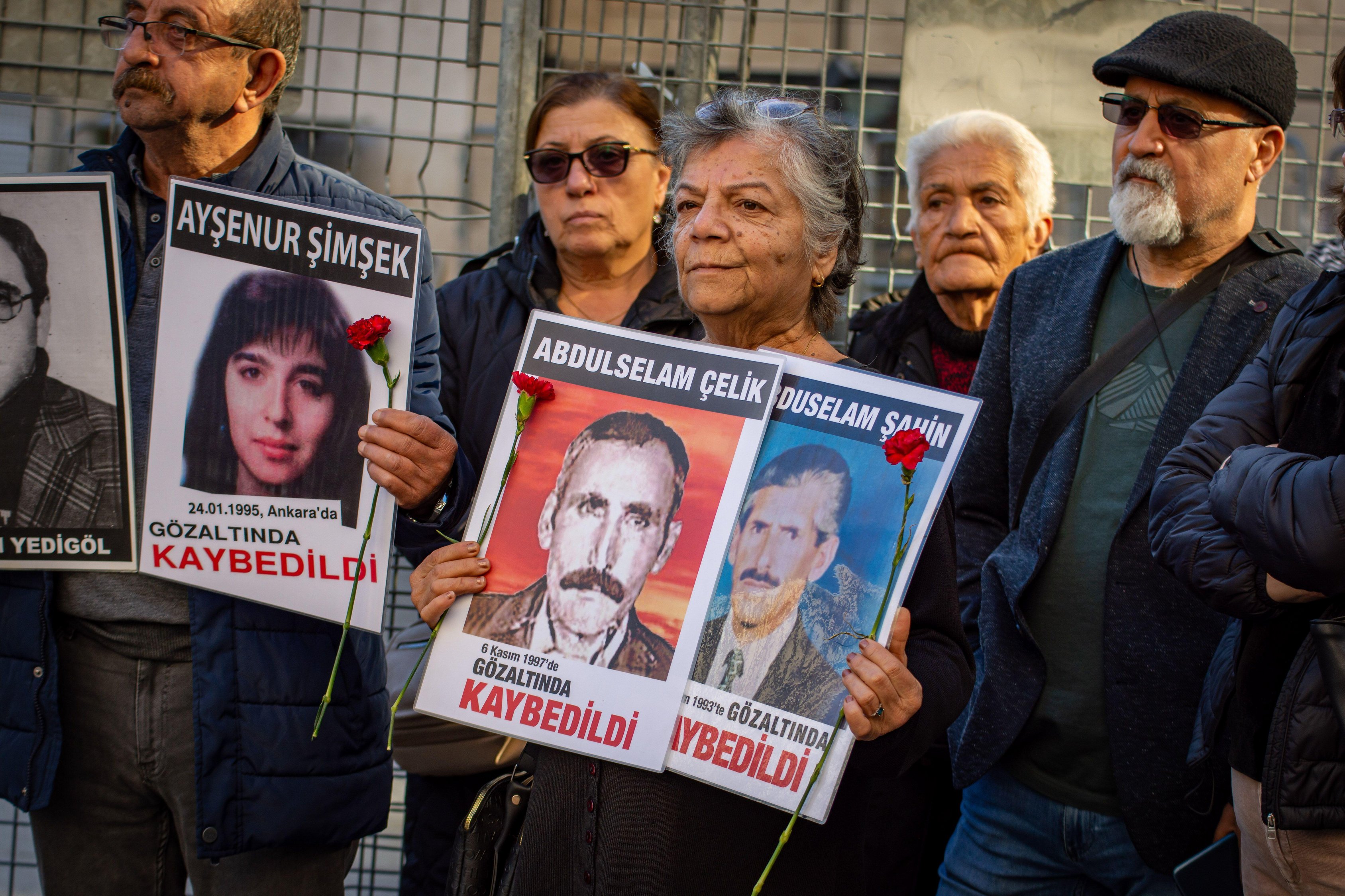 People protesting with signs of disappeared persons.