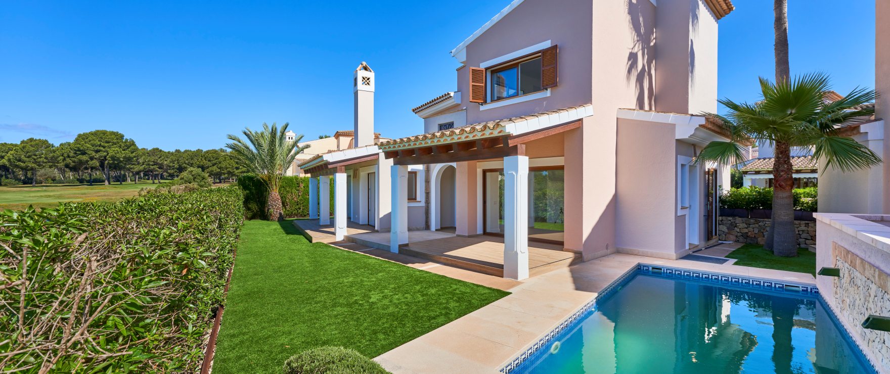 A luxurious Marina Golf villa in Nova Santa Ponsa, Mallorca, with a private pool, landscaped garden, and golf course views.