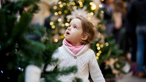 Excited little girl looking at christmas trees