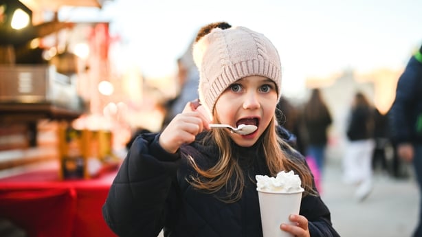 child eating whipped cream at Christmas market.