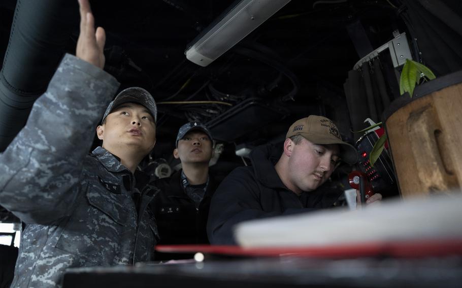 U.S.  and South Koean navy sailors discuss maneuvers aboard the USS Dewey during the Maritime Counter Special Operations Exercise in South Korea, Nov. 18, 2025. 