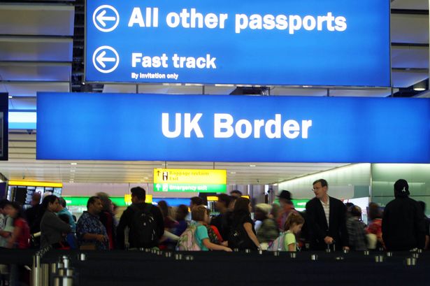 Passengers going through border control at an airport.