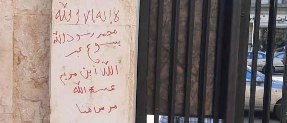 Graffiti in red on the wall of a church