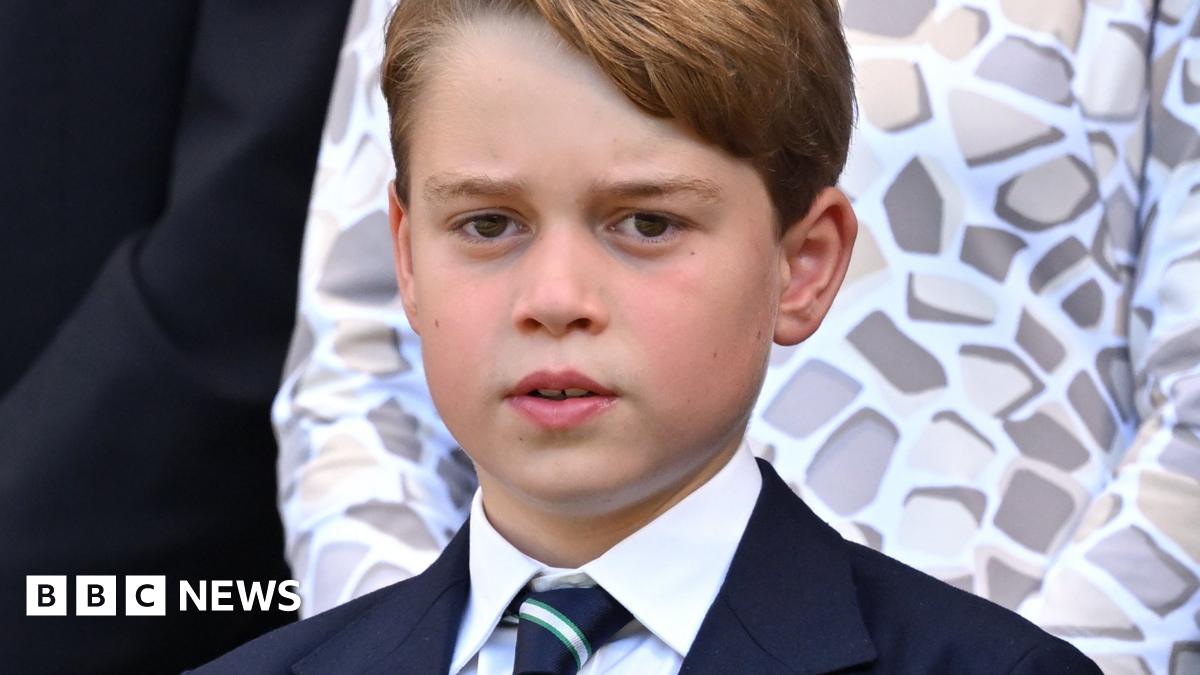 Two housemates stand in their kitchen, smiling at the camera