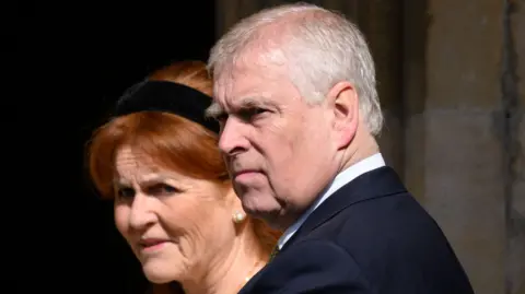 Getty Images A file photo from the 2025 Easter Service at St George's Chapel in Windsor of the then-Prince Andrew, wearing a dark suit and pictured in a three-quarter view, with Sarah Ferguson, who has a black Alice band in her hair, standing behind him.