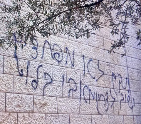 Graffiti on the wall of a mosque targeted by settlers in the West Bank