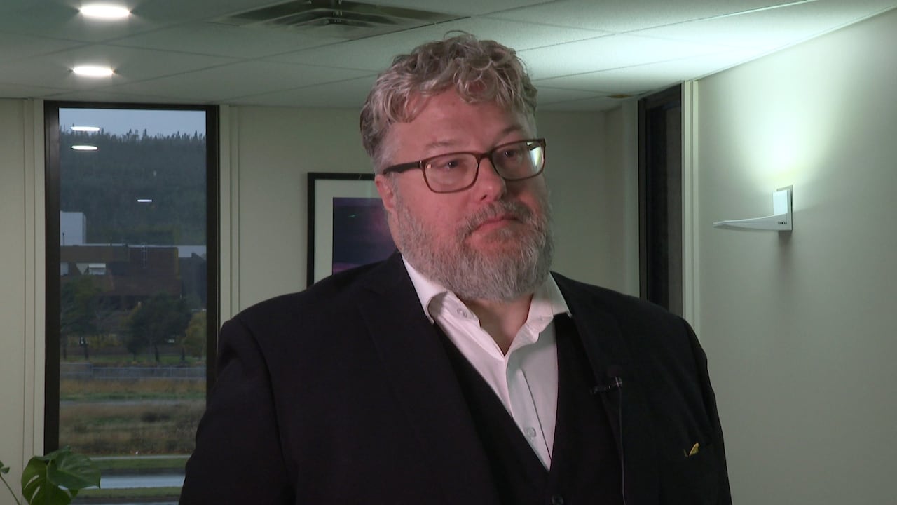 Man in three piece suit stands in hallway