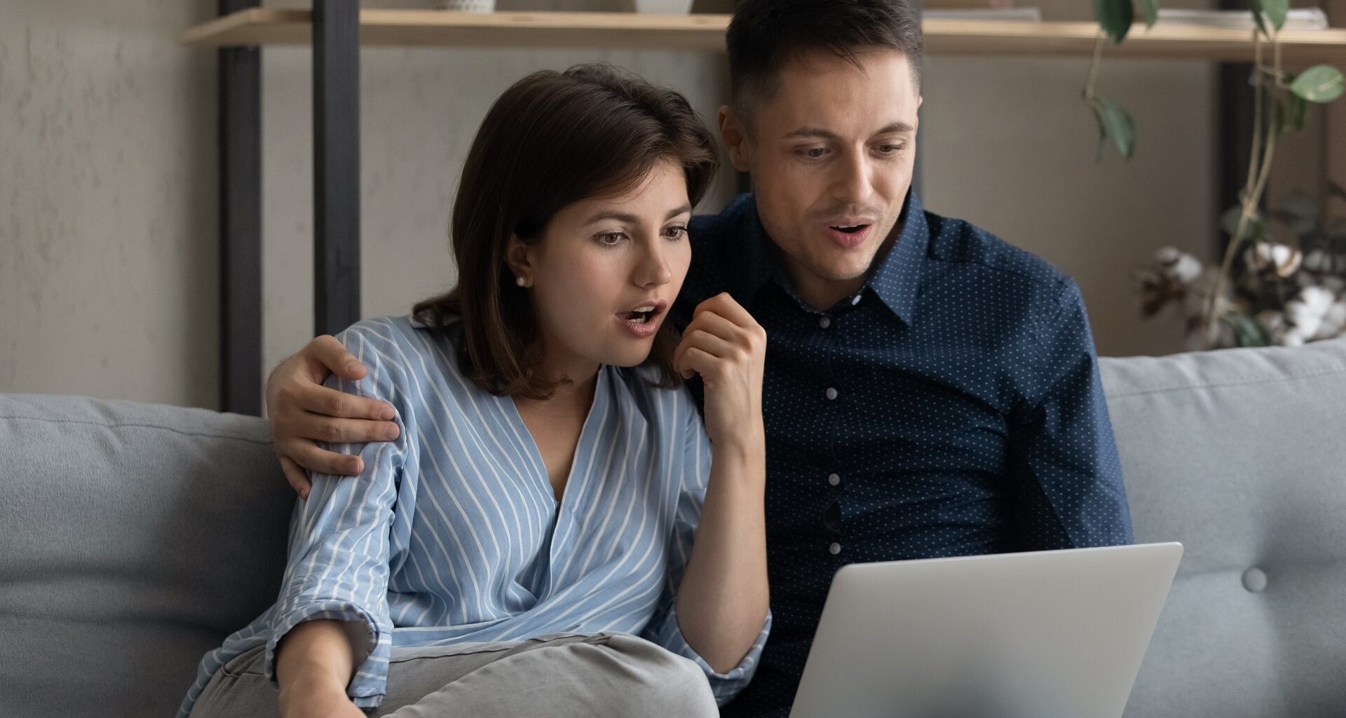 Excited surprised dating couple reading email message on laptop stock photo