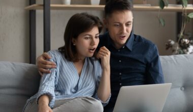 Excited surprised dating couple reading email message on laptop stock photo