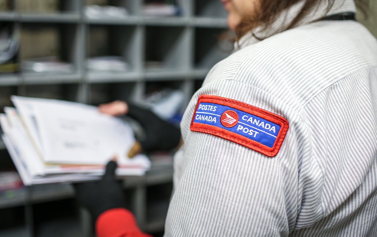 Postal worker sorts through mail.