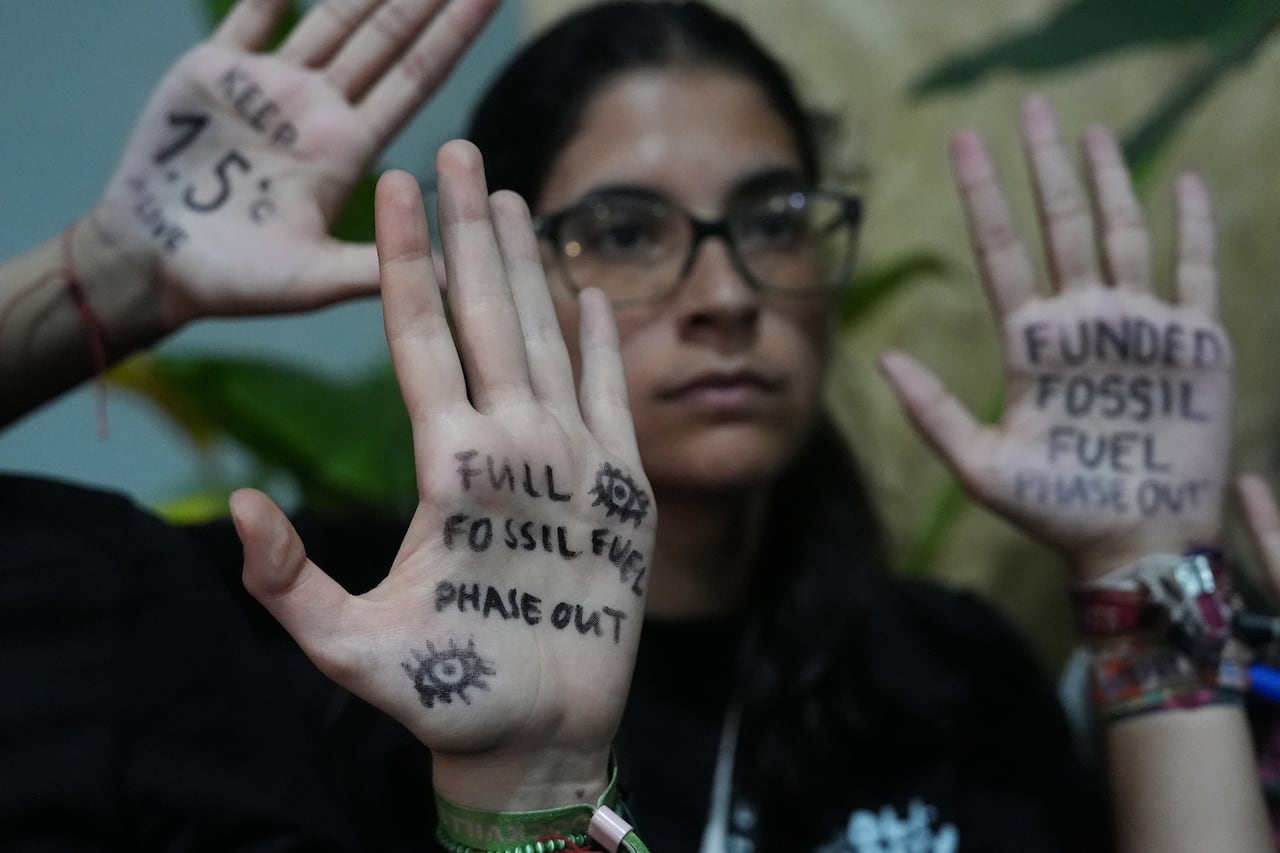 Demonstrators hold up their hands to display written messages.